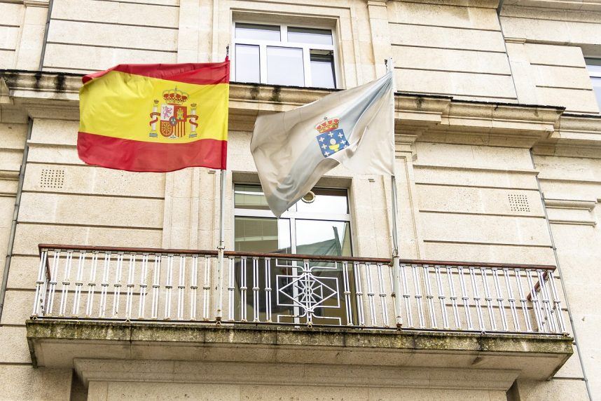 The flags of Spain and the autonomous community of Galicia fly on a balcony